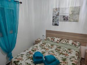 a bedroom with a bed with two blue towels on it at Estudio Alicia in Rota