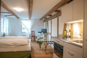 a bedroom with a bed and a kitchen with a sink at 3 Sterne Boutique Gasthaus Pöstli in Rifferswil