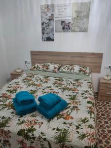 Una cama con dos almohadas azules encima. en Estudio Alicia, en Rota