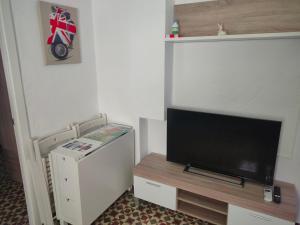 a living room with a flat screen tv and a refrigerator at Estudio Alicia in Rota