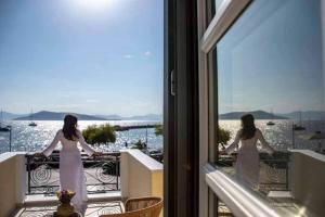 two women standing on a balcony looking out at the water at Naias Aegina, Sea-front apartment 95 sqm in Egina