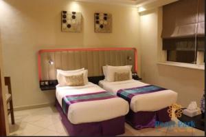 a bedroom with two beds in a room at Pearl Executive Hotel Apartments in Dubai