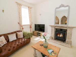 a living room with a couch and a fireplace at 4 The Old Council House in Shipston on Stour