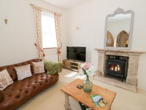 ein Wohnzimmer mit Couch und Kamin in der Unterkunft 4 The Old Council House in Shipston on Stour
