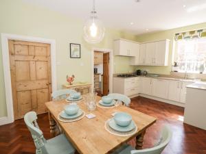 una cucina e una sala da pranzo con tavolo e sedie in legno di 4 The Old Council House a Shipston-on-Stour