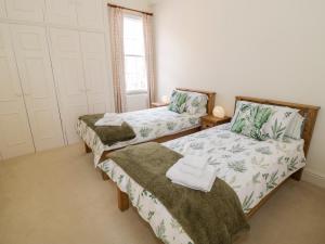 ein Schlafzimmer mit zwei Betten und einem Fenster in der Unterkunft 4 The Old Council House in Shipston on Stour