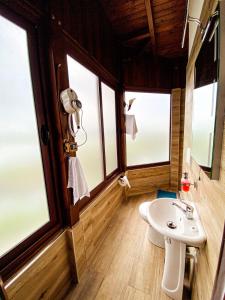 łazienka z umywalką i 2 oknami w obiekcie Hotel Iliria w Szkodrze