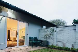 a patio with chairs and a table in front of a house at Clifton Home in Richards Bay