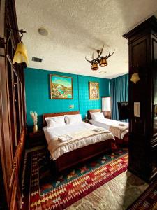 sypialnia z 2 łóżkami i niebieską ścianą w obiekcie Hotel Iliria w Szkodrze