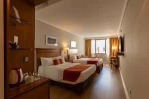 una camera d'albergo con due letti e una finestra di Blank Hotel Recoleta a Buenos Aires