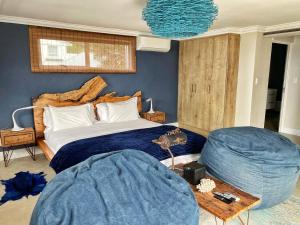 a bedroom with a large bed with blue walls at Residence William French in Simonʼs Town