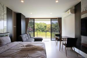 a bedroom with a bed and a table and a window at Escape Condominium By A property in Mae Pim +36 photos