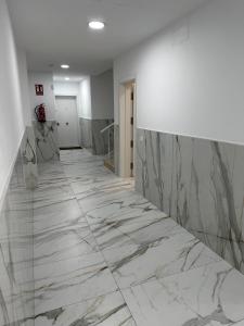 um corredor com piso em mármore num edifício em Magnificent and New apartment in Playa San Juan em Guía de Isora