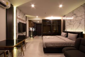 a bedroom with a bed and a table and a couch at Escape II CondominiumE225 in Mae Pim +14 photos