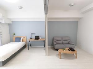 - une chambre avec un lit, une chaise et une table dans l'établissement ESLEAD HOTEL Namba Daikokucho, à Osaka