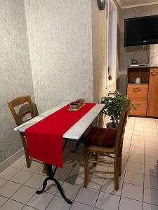 a red and white table with two chairs and a tv at Le Clos du Chateau Rouge 3* avec Parking securisé in Annemasse