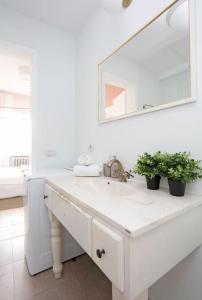 a white bathroom with a sink and a mirror at University Apartment in Bucharest