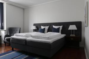 een slaapkamer met een groot bed met blauwe kussens bij Helnan Phønix Hotel in Aalborg