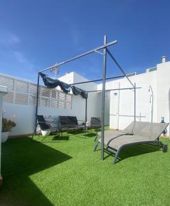 a patio with a swing set on the grass at CABO BEACH II in El Cabo de Gata
