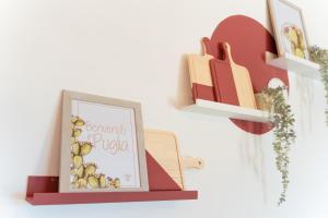 ein Regal mit einem Bild von Apulien an einer Wand in der Unterkunft ITRIUM Homes & Suites in Valle d'Itria in Alberobello