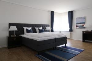 een slaapkamer met een groot bed met blauwe kussens bij Helnan Phønix Hotel in Aalborg