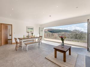 a dining room with a table and a large window at Larchwood Lodge in Old Radnor