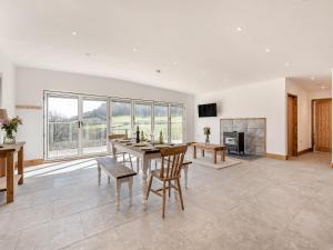 a living room with a table and chairs and a fireplace at Larchwood Lodge in Old Radnor