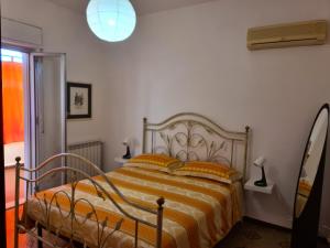 una camera da letto con un letto con lenzuola a righe arancioni e gialle di Mondello Sunrise a Mondello