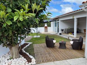 a patio with two chairs and a tree at Moradia alegre no centro da Vila da Tocha. in Tocha
