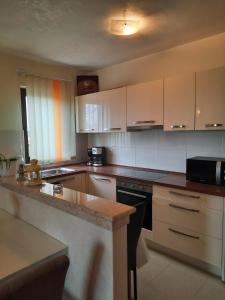 a kitchen with white cabinets and a granite counter top at APP Mario Funtana in Funtana