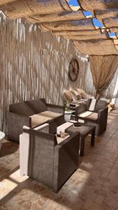 sala de estar con sofás, mesas y techo en Hotel Tabby, en Golfo Aranci