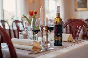 - une bouteille de vin assise sur une table avec des verres à vin dans l'établissement Munkedals Herrgård, à Munkedal