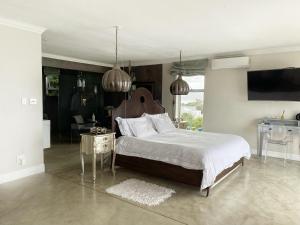 a bedroom with a large bed and a table at Residence William French in Simonʼs Town