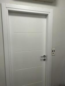 a white door with a silver handle in a room at Kršić Apartman in Baošići