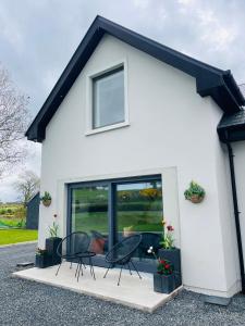 una casa bianca con due sedie e finestre di Country Hideaway a Milltown