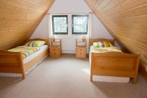 a attic room with two beds and a window at Ferienhaus Zinnwald in Kurort Altenberg
