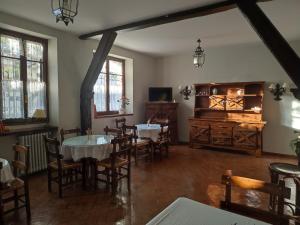 uma sala de jantar com mesas e cadeiras e uma televisão em Conde Aznar em Jaca