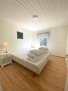 a large white bedroom with a bed and a window at Tosthult Holiday 2 in Lönsboda