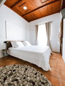 una camera da letto con un grande letto bianco e una finestra di Casa SaloYa a Sintra