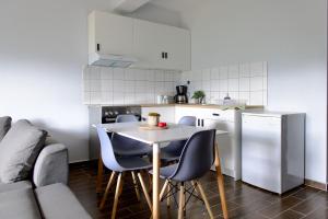 a kitchen with a table and chairs and a couch at Ολόκληρο Διαμέρισμα η Βυσσινιά in Kotrónion +6 photos