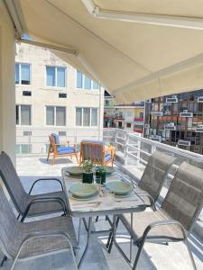 een patio met een tafel en stoelen op een balkon bij Domus City Apartment with wonderful balcony in Thessaloniki