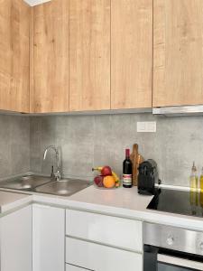 uma cozinha com armários brancos, um lavatório e uma taça de fruta em Domus City Apartment with wonderful balcony em Tessalônica