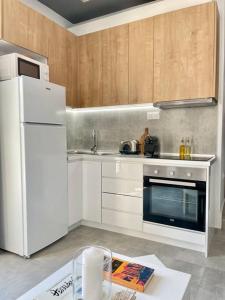 uma cozinha com electrodomésticos brancos e armários de madeira em Domus City Apartment with wonderful balcony em Tessalônica