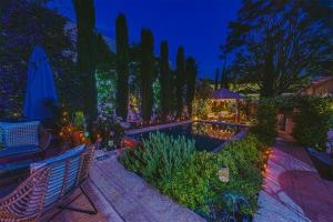 a garden at night with a pool and trees at Boutique B&B Suite at Casa Grande in Pinoso