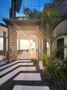 une maison avec un palmier au milieu d'une passerelle dans l'établissement Villa Seawadee - luxurious, award-winning design Villa with amazing panoramic seaview, à Chaweng Noi Beach