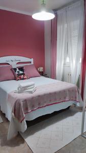 1 dormitorio con 1 cama blanca grande y paredes rojas en Mascotas Brais en San Miguel de Reinante