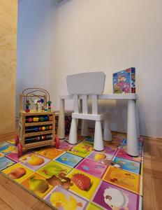 een kinderkamer met een tafel en een kleed bij Duga Apartmani 2 in Subotica