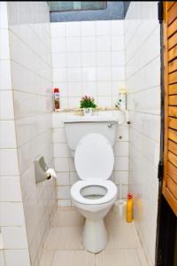 een badkamer met een wit toilet in een stal bij Mavericks Convenient Cozy Loft in Diani's CBD in Ukunda