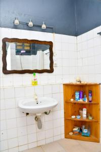 a bathroom with a sink and a mirror at Mavericks Convenient Cozy Loft in Diani's CBD in Ukunda