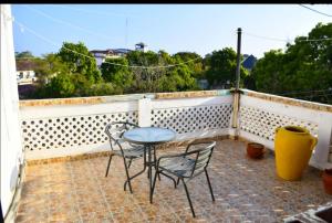 een patio met een tafel en stoelen op een balkon bij Mavericks Convenient Cozy Loft in Diani's CBD in Ukunda